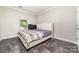 Neutral bedroom with a stylish upholstered headboard, gray vinyl flooring, and a bright window at 5098 Burnwald Ct, Fort Mill, SC 29715