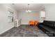 Comfortable living room featuring gray tile floors, neutral walls, and a chandelier-style ceiling light at 5098 Burnwald Ct, Fort Mill, SC 29715