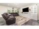 Bright living room featuring grey floors, comfortable seating, modern decor, and natural light from large windows at 5098 Burnwald Ct, Fort Mill, SC 29715