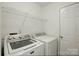 Functional laundry room area featuring modern washer and dryer units with wire rack at 611 Annalinde Ln, Rock Hill, SC 29732
