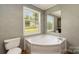Corner soaking tub with a window for natural light, providing a spa-like experience at 828 Carver St # 17-19, Shelby, NC 28152