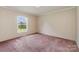 The bedroom has a window overlooking the yard with pink carpeting at 828 Carver St # 17-19, Shelby, NC 28152