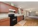 Bright kitchen featuring black appliances, warm wood cabinets and an adjacent living space at 828 Carver St # 17-19, Shelby, NC 28152