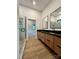 A spacious bathroom with double sink vanity, framed mirrors, and a marble-tiled walk-in shower at 908 Apex Dr, Albemarle, NC 28001