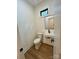 Compact powder room featuring modern fixtures, a floating sink, and wood-look flooring at 908 Apex Dr, Albemarle, NC 28001
