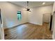 A bright bedroom with light-colored walls, wood flooring, and a sleek black ceiling fan at 908 Apex Dr, Albemarle, NC 28001