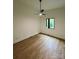 A clean, empty bedroom featuring sleek wooden floors, a window and a contemporary ceiling fan at 908 Apex Dr, Albemarle, NC 28001