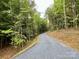 Gravel driveway leading into lush green trees and foliage at 908 Apex Dr, Albemarle, NC 28001