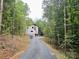 Modern home with a gravel driveway surrounded by mature trees at 908 Apex Dr, Albemarle, NC 28001