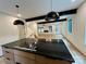 Open kitchen with sleek black countertops, island cooktop, and a view into the living area at 908 Apex Dr, Albemarle, NC 28001