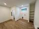 Bright laundry room with wood-look floors, built-in shelves, and a small window at 908 Apex Dr, Albemarle, NC 28001