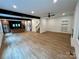 Open concept living room, featuring modern kitchen, staircase, hardwood floors, and lots of natural light at 908 Apex Dr, Albemarle, NC 28001