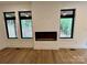 View of a modern fireplace between two large windows in a well-lit room at 908 Apex Dr, Albemarle, NC 28001