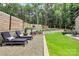 Tranquil backyard lounge area with patio furniture, gravel bed, retaining walls, and beautiful landscaping at 9423 Man O War Rd, Fort Mill, SC 29707