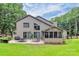 Expansive backyard with a patio, screened porch, lush lawn, and mature trees, creating a private oasis at 9423 Man O War Rd, Fort Mill, SC 29707