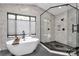 Bathroom with a soaking tub under a window and a modern shower with glass enclosure at 9423 Man O War Rd, Fort Mill, SC 29707