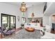 Bright living room featuring high ceilings, modern lighting, and a view to the kitchen and backyard at 9423 Man O War Rd, Fort Mill, SC 29707
