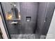 Modern shower featuring black textured tile, a glass door, and a mosaic tile floor at 9423 Man O War Rd, Fort Mill, SC 29707