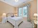 Cozy bedroom with a large window, carpeted floors, and a decorative bedspread with floral curtains at 964 Knob Creek Ln, Fort Mill, SC 29708