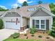 Charming home showcasing a front-facing garage, manicured landscaping, and stone accents under the windows at 964 Knob Creek Ln, Fort Mill, SC 29708