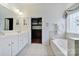 Bright main bathroom with a double vanity, soaking tub, and access to the closet at 964 Knob Creek Ln, Fort Mill, SC 29708