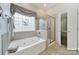 Relaxing main bathroom featuring a soaking tub, a glass-enclosed shower, and natural light at 964 Knob Creek Ln, Fort Mill, SC 29708