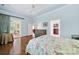 Light-filled main bedroom with a tray ceiling, hardwood floors, and access to the sunroom at 964 Knob Creek Ln, Fort Mill, SC 29708