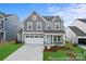 Two-story home featuring a gray facade, manicured lawn, and a two-car garage at 9858 Jack Nicklaus Dr # 897, Lancaster, SC 29720