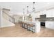 Open kitchen with white cabinets, a large island with barstools, and modern pendant lighting at 9858 Jack Nicklaus Dr # 897, Lancaster, SC 29720