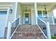 Inviting front entrance with brick steps, white railings, and a sleek gray front door at 102 Starmount Dr, Kings Mountain, NC 28086