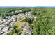 Community aerial view nestled among lush greenery with blue skies and homes with various roof colors at 111 Trails End Ln, New London, NC 28127