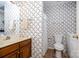 Traditional bathroom with a single sink vanity, toilet, and a shower with a curtain in a patterned wallpaper setting at 111 Trails End Ln, New London, NC 28127
