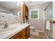 Bathroom with double sinks, wooden cabinets, a shower, and floral wallpaper at 111 Trails End Ln, New London, NC 28127