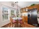 Dining area with natural light, hardwood floors, and black stainless steel refrigerator at 111 Trails End Ln, New London, NC 28127