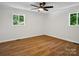 Bedroom with wood flooring and a ceiling fan, illuminated by natural light from two windows at 1123 Timberlane Dr, Lincolnton, NC 28092