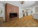 Updated living room with refinished hardwood floors, large fireplace, and modern kitchen at 1123 Timberlane Dr, Lincolnton, NC 28092