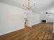 Open-concept living space with refinished hardwood floors and a white brick fireplace at 1123 Timberlane Dr, Lincolnton, NC 28092
