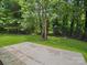 Concrete patio surrounded by lush green grass and mature trees offering shade and privacy at 1123 Timberlane Dr, Lincolnton, NC 28092