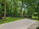 Concrete patio surrounded by lush green grass and mature trees offering shade and privacy at 1123 Timberlane Dr, Lincolnton, NC 28092