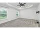 Large bedroom with tray ceiling, carpet floors, and bright windows at 13022 Rover St, Charlotte, NC 28273