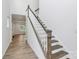 View of wooden staircase with white rails, fresh paint, and wood floors at 13022 Rover St, Charlotte, NC 28273