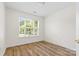 Bright bedroom with wood-look flooring, a large window, and white walls at 131 Canopy Ct, Mooresville, NC 28115