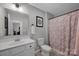 Well-lit bathroom featuring a white vanity, framed mirror, and a shower with a decorative curtain at 1315 Elizabeth Ave, Kannapolis, NC 28083