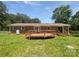 Spacious backyard with a wooden deck, lush green lawn, mature trees, and a brick exterior at 132 Windy Hill Rd, Statesville, NC 28625