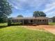 Charming single-story home with brick and vinyl siding, complemented by mature landscaping and a sunny front yard at 132 Windy Hill Rd, Statesville, NC 28625