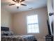 A cozy bedroom features a ceiling fan, window with blinds, and comfortable-looking bed at 14411 Glendon Hall Ln, Charlotte, NC 28262