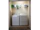 A functional laundry area features a washer, dryer, shelving, and convenient storage at 14411 Glendon Hall Ln, Charlotte, NC 28262