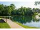Tranquil pond featuring a bridge, lush trees reflected in the calm water at 14411 Glendon Hall Ln, Charlotte, NC 28262