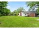 Spacious backyard view showcasing a large grassy area and the home's brick and vinyl siding at 1512 Anthony Dr, Gastonia, NC 28052