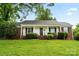 Charming home featuring a well-manicured lawn and front porch, set against a clear, blue sky at 1512 Anthony Dr, Gastonia, NC 28052